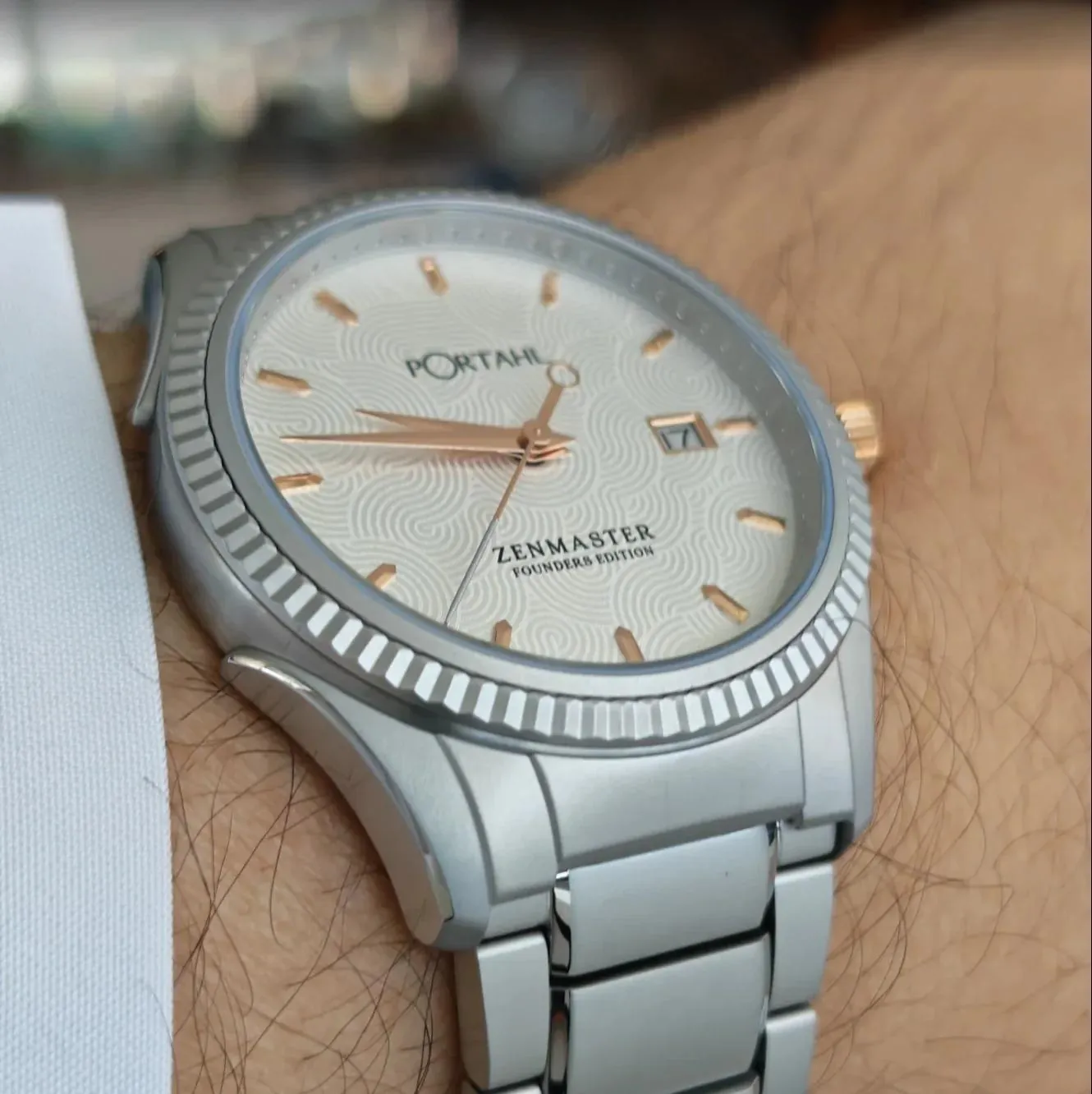 pOrtahl Zenmaster Founder's Edition watch on the wrist, showing its textured dial, rose gold accents, fluted bezel, and integrated bracelet.