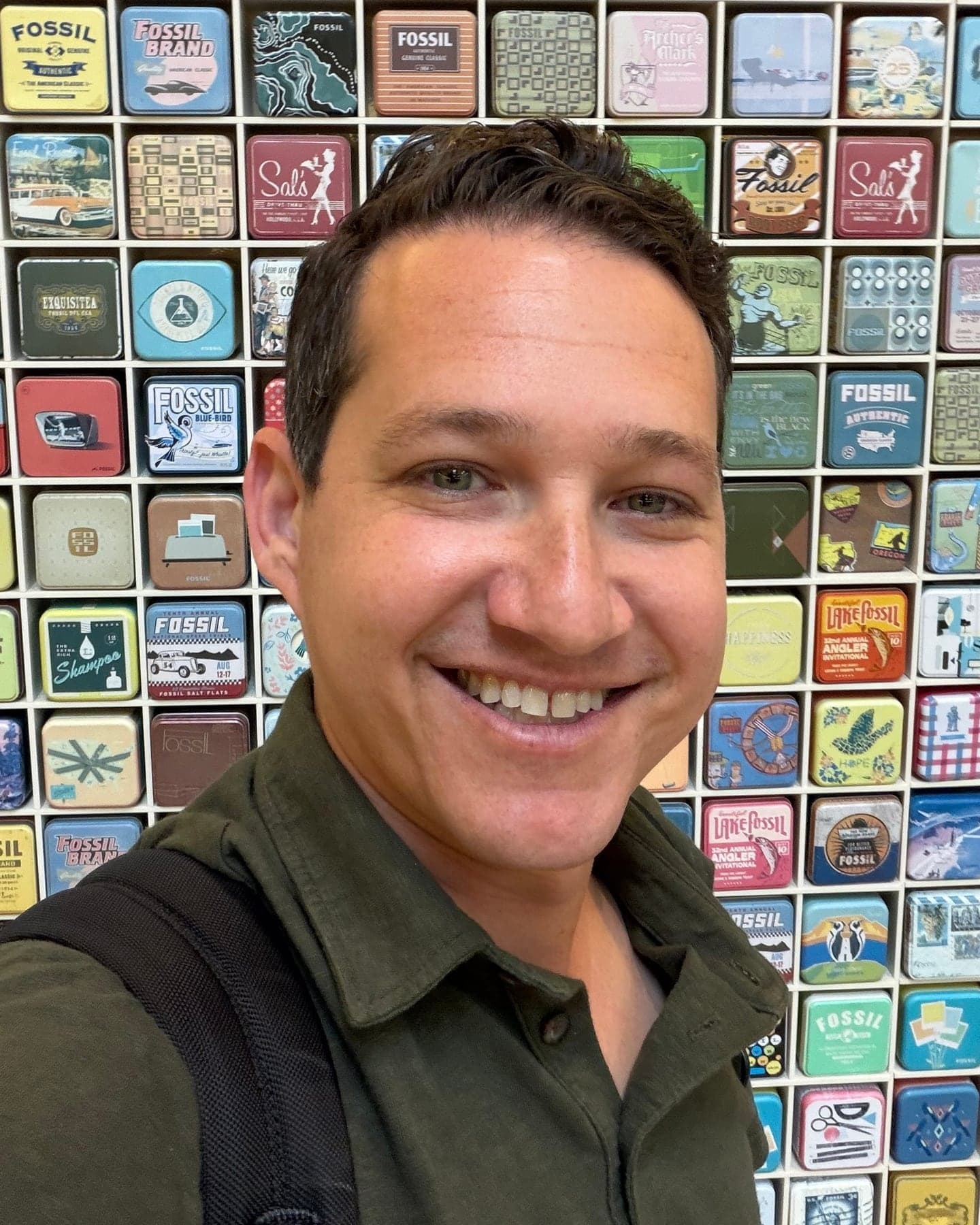 Justin Dorfman, founder of Zeon Micro, in front of a wall of collectible watch tins